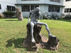 01B Sculpture of a solitary thin man sitting on a rock at the entrance to the grounds of the Olympia Gallery The Art Centre Kingston Jamaica